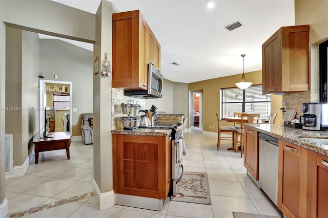 kitchen with light tile patterned flooring, decorative light fixtures, tasteful backsplash, stainless steel appliances, and light stone countertops