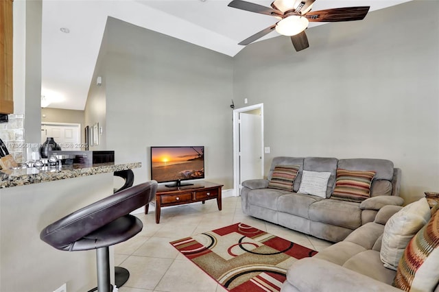 living room featuring ceiling fan, a high ceiling, and light tile patterned floors