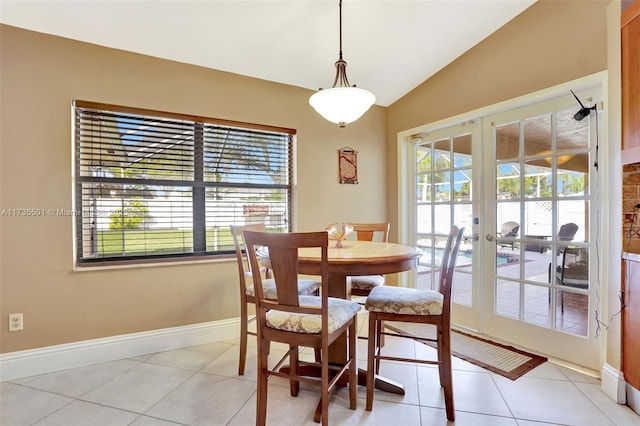 tiled dining room with french doors, a healthy amount of sunlight, and vaulted ceiling