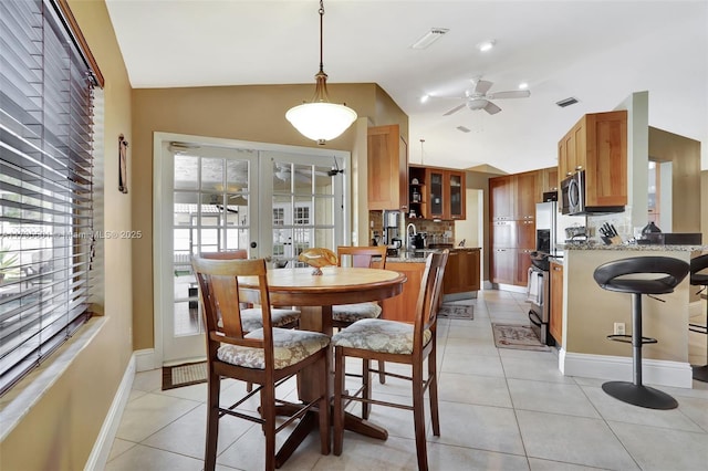 dining area featuring lofted ceiling, light tile patterned floors, and french doors