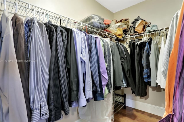 walk in closet with dark wood-type flooring