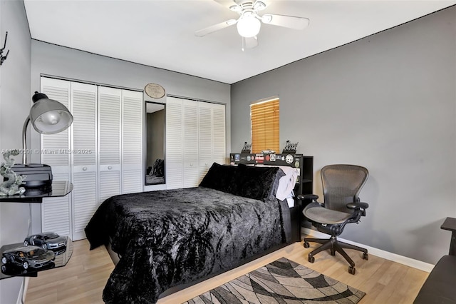 bedroom featuring multiple closets, ceiling fan, and light wood-type flooring