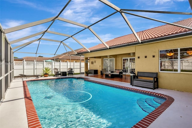 view of pool with a lanai, a patio area, french doors, and ceiling fan