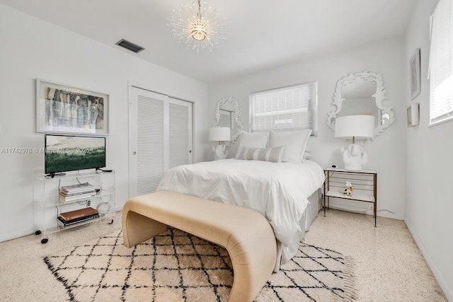 bedroom with multiple windows, a closet, and an inviting chandelier