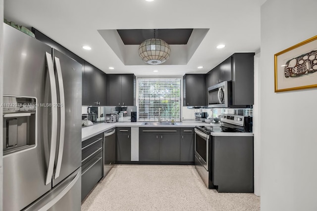 kitchen with stainless steel appliances, a raised ceiling, and sink