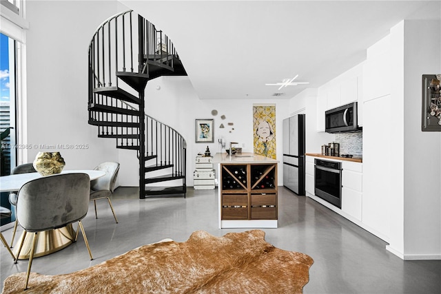 kitchen with white cabinets, stainless steel appliances, and tasteful backsplash