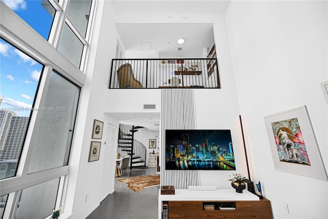 living room featuring a high ceiling and concrete floors