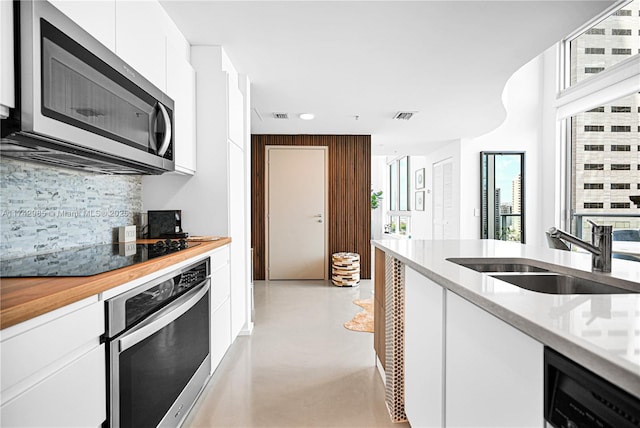 kitchen featuring sink, white cabinets, stainless steel appliances, and plenty of natural light