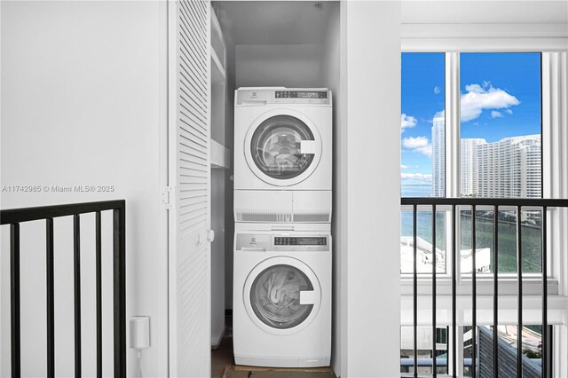 laundry room with a water view and stacked washing maching and dryer