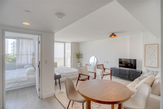 bedroom with multiple windows and light hardwood / wood-style flooring