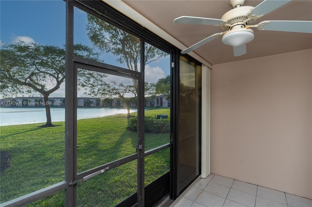 unfurnished sunroom featuring ceiling fan, a healthy amount of sunlight, and a water view