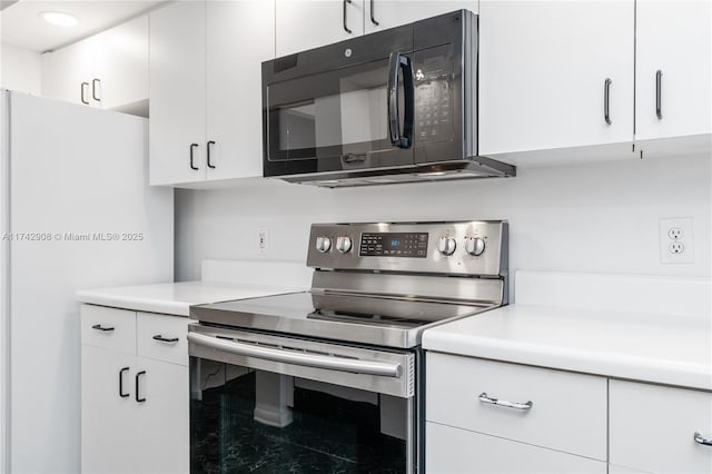 kitchen featuring white cabinetry, white refrigerator, and stainless steel electric range