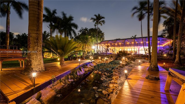 deck at dusk featuring a lanai