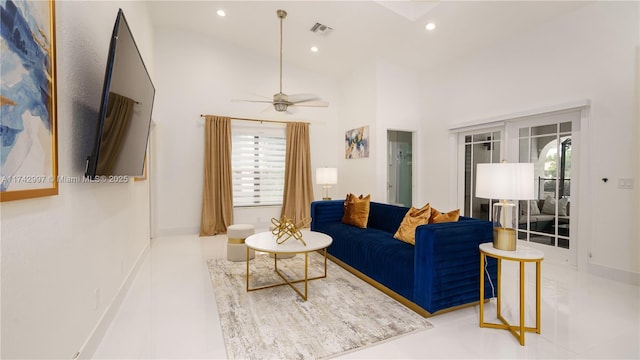 living room featuring ceiling fan and a high ceiling