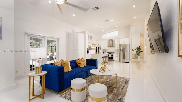 living room with ceiling fan and high vaulted ceiling