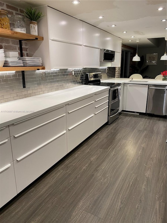 kitchen with decorative light fixtures, white cabinetry, dark hardwood / wood-style flooring, decorative backsplash, and stainless steel appliances