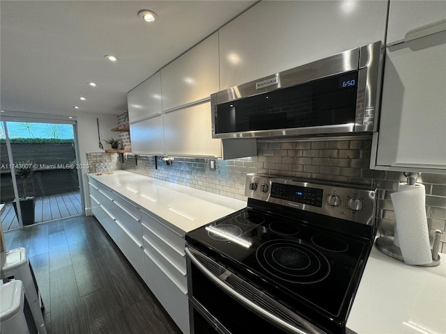 kitchen featuring white cabinetry, range with electric cooktop, dark wood-type flooring, and decorative backsplash