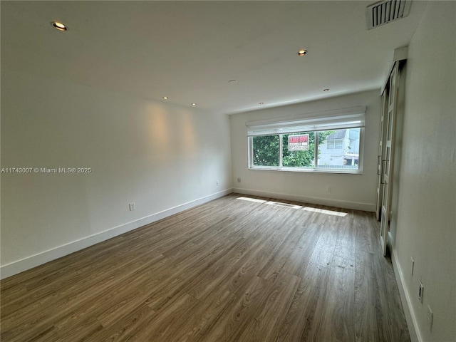 unfurnished room with hardwood / wood-style floors