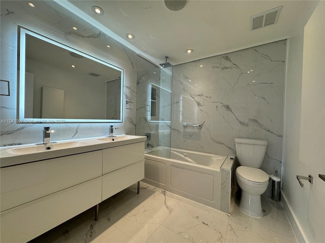 full bathroom with tiled shower / bath, vanity, toilet, and tile walls