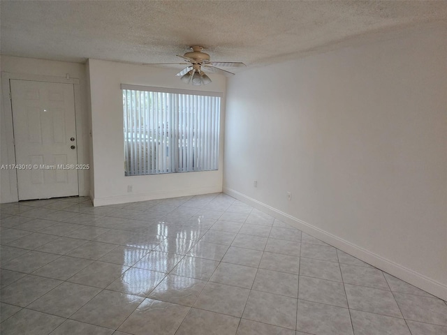 spare room featuring light tile patterned floors, a textured ceiling, and ceiling fan