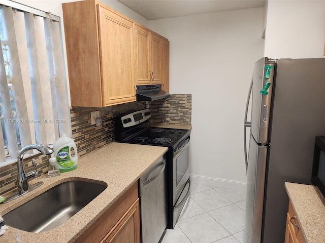 kitchen with tasteful backsplash, sink, light tile patterned floors, and appliances with stainless steel finishes