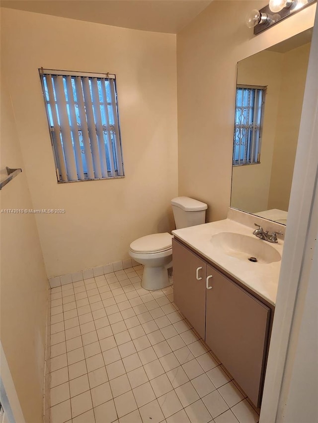 bathroom with tile patterned flooring, vanity, and toilet