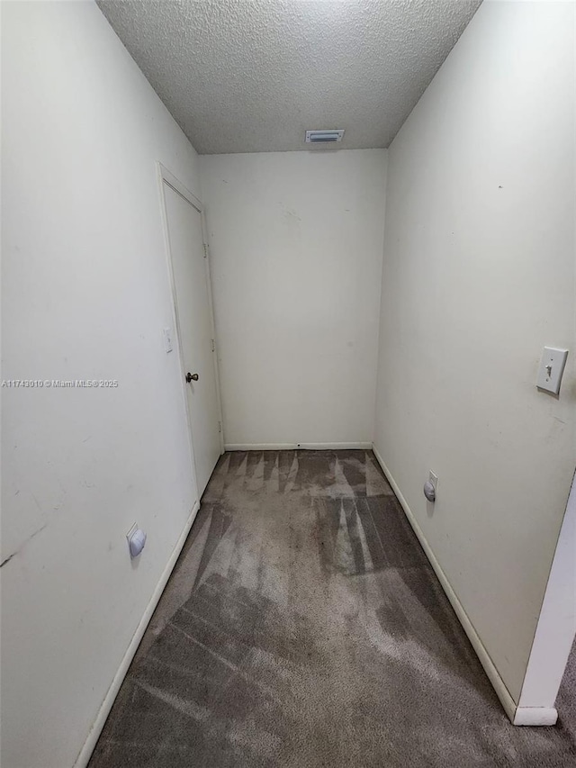 empty room with carpet floors and a textured ceiling