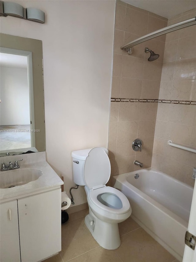 full bathroom featuring tiled shower / bath, vanity, toilet, and tile patterned flooring