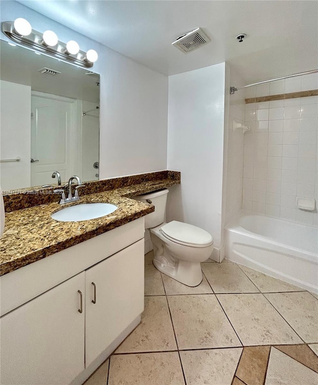 full bathroom with tile patterned flooring, vanity, tiled shower / bath, and toilet