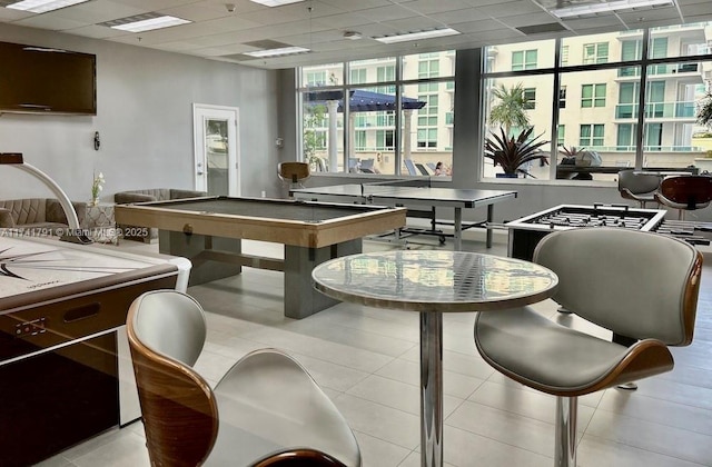 rec room with light tile patterned floors and a drop ceiling