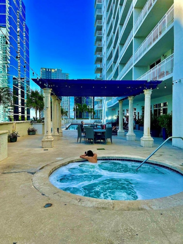 view of pool featuring a community hot tub and a patio