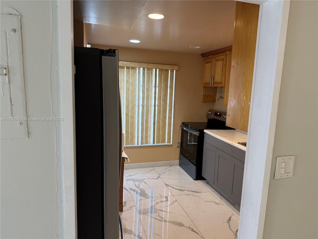 kitchen featuring black range with electric stovetop, stainless steel fridge, and gray cabinets