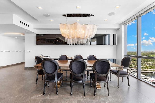 dining space featuring floor to ceiling windows and a chandelier