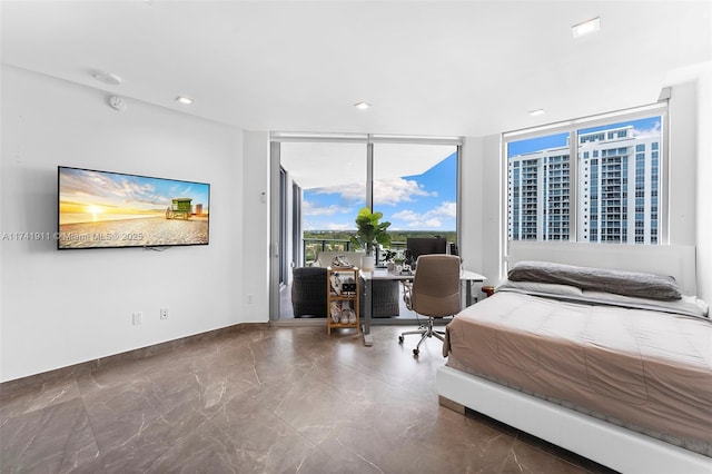 bedroom featuring expansive windows and access to exterior