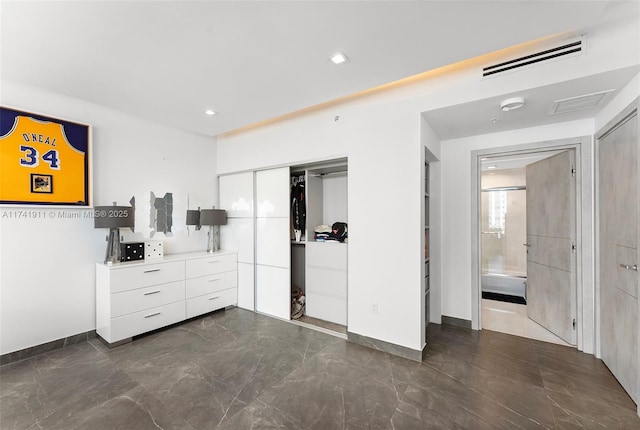 unfurnished bedroom featuring a closet and ensuite bathroom