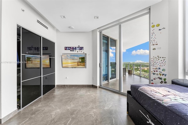 bedroom featuring access to exterior and a wall of windows