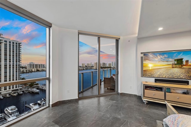 unfurnished living room featuring floor to ceiling windows and a water view