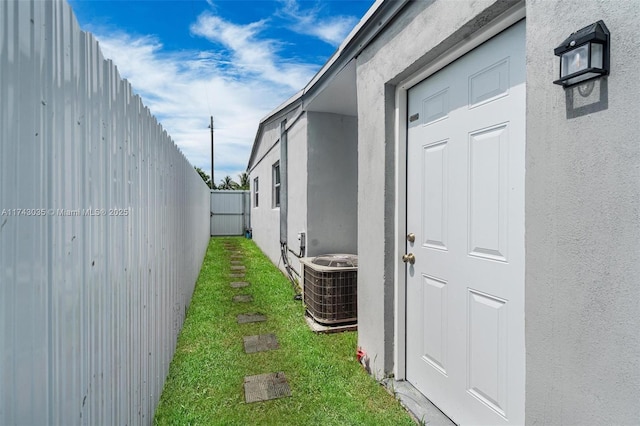 view of side of property featuring a lawn and central air condition unit