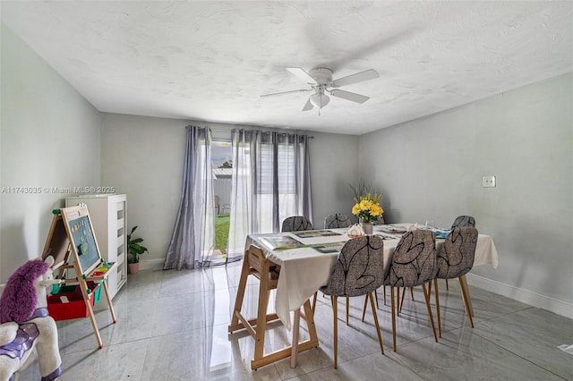 dining area featuring ceiling fan and a textured ceiling