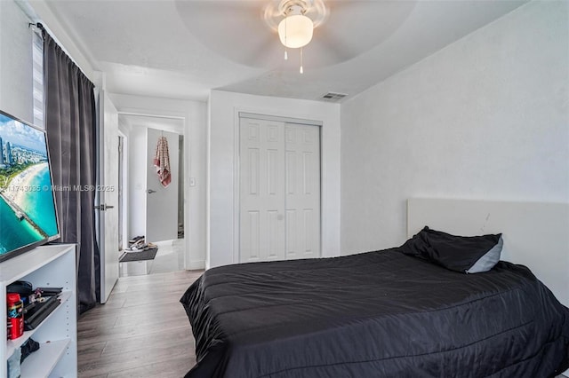 bedroom featuring light hardwood / wood-style flooring, a closet, and ceiling fan