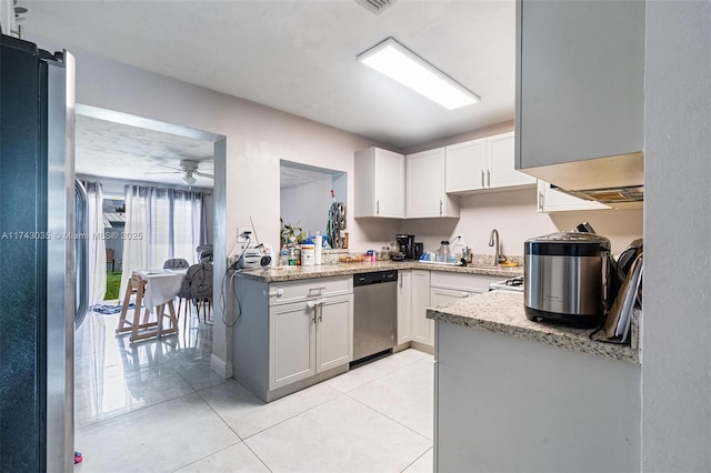 kitchen with white cabinetry, light tile patterned floors, light stone countertops, and appliances with stainless steel finishes