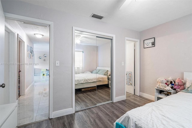 bedroom featuring dark hardwood / wood-style floors, ceiling fan, and a closet