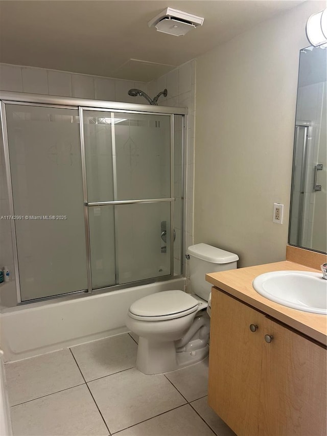 full bathroom featuring vanity, tile patterned floors, shower / bath combination with glass door, and toilet