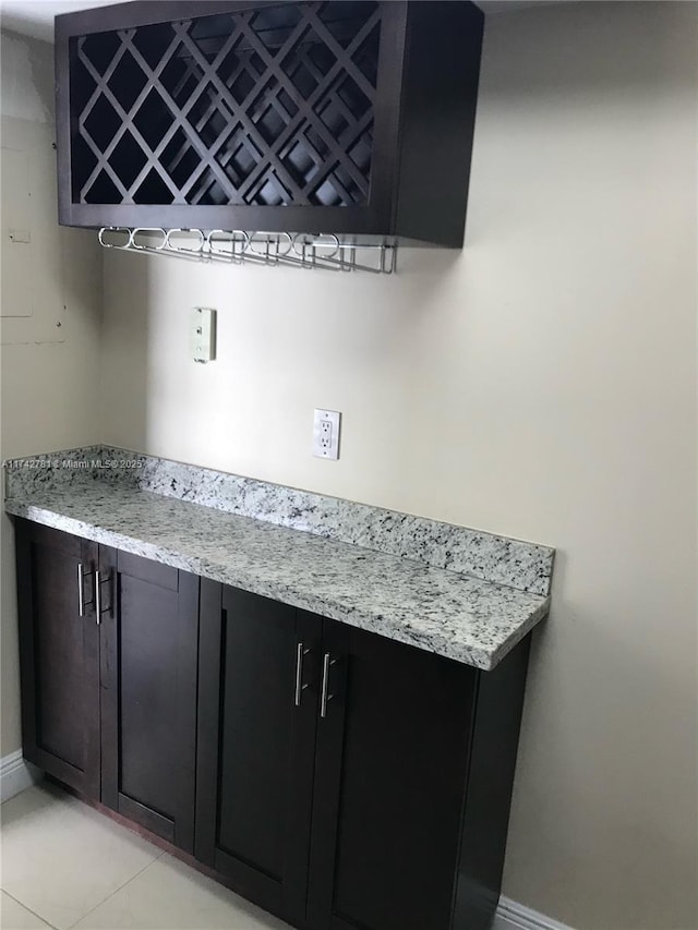 interior space with light tile patterned floors and light stone counters