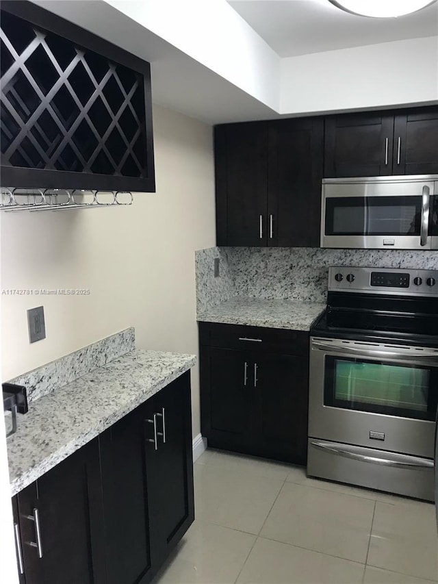 kitchen featuring light stone countertops, appliances with stainless steel finishes, and light tile patterned floors