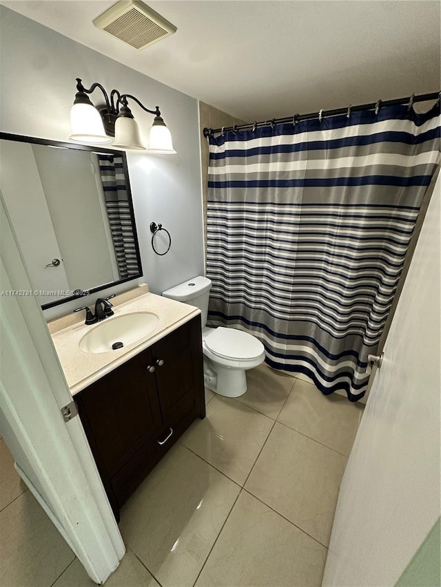 bathroom with tile patterned flooring, vanity, and toilet