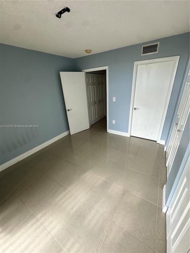 unfurnished bedroom with a textured ceiling