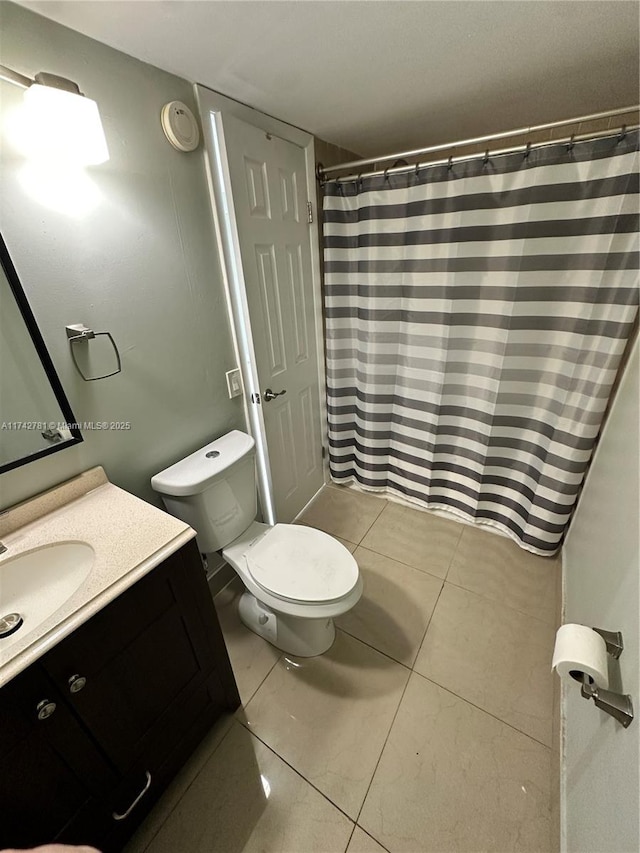 bathroom with vanity, tile patterned flooring, and toilet