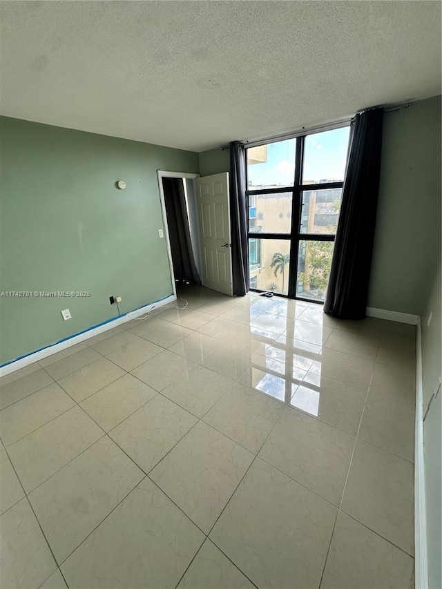 empty room featuring expansive windows and a textured ceiling