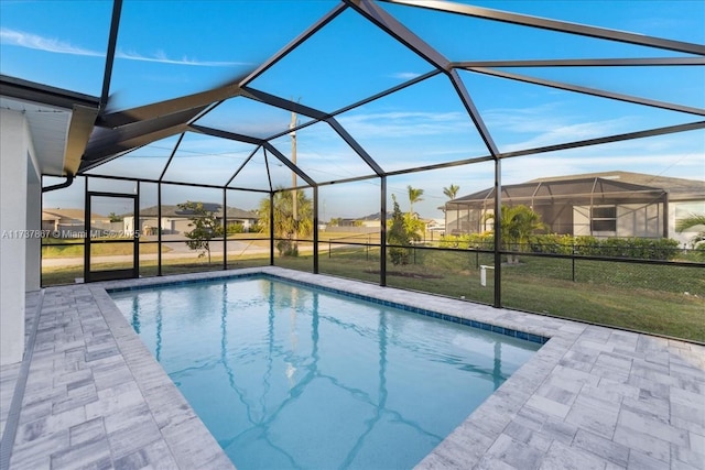 view of swimming pool with a patio, a lanai, and a lawn